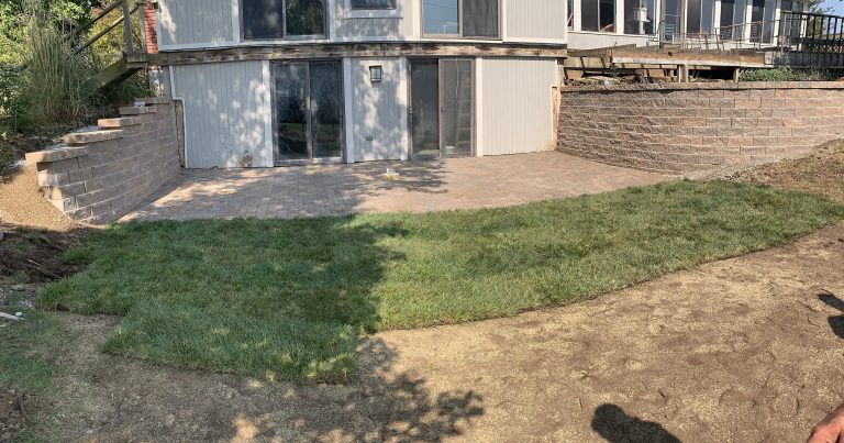 After: replacement block walls and a patio beside the entrance.