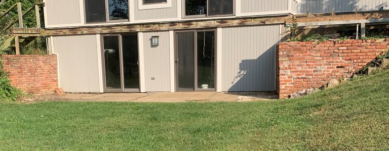 Before: brick retaining walls beside the lower-level entrance.